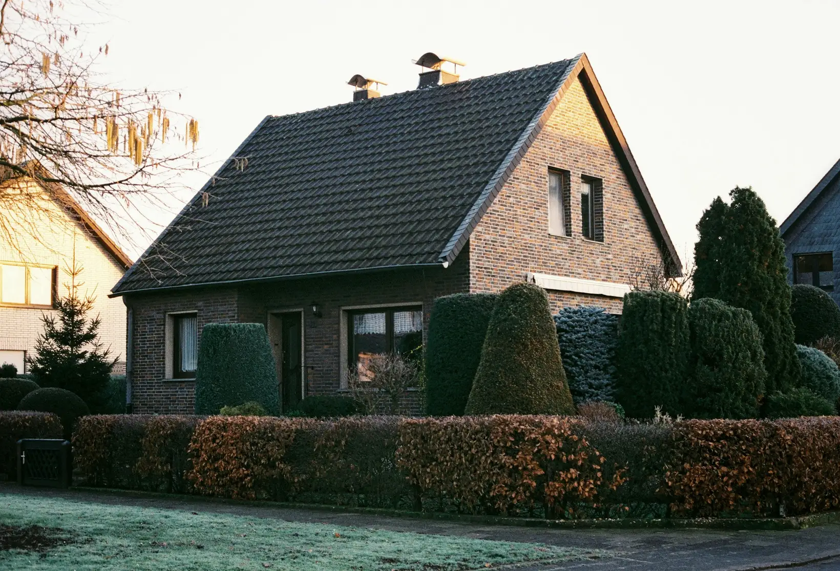 Einfamilienhaus mit Hecke und Garten